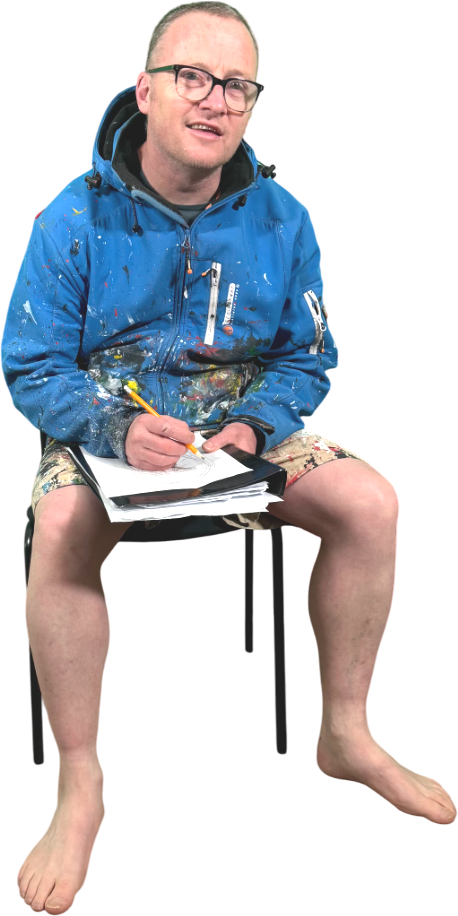 Motta Artist sitting down drawing with blue coat and shorts on